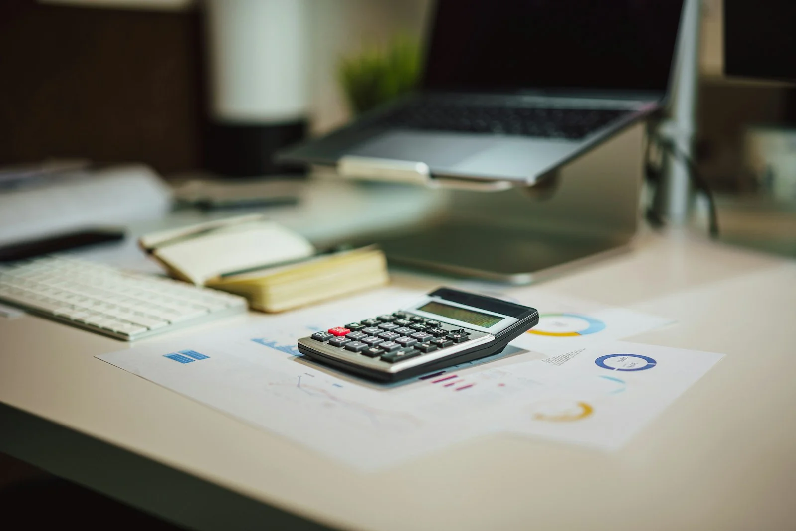 Bureau avec calculatrice, graphiques et ordinateur portable