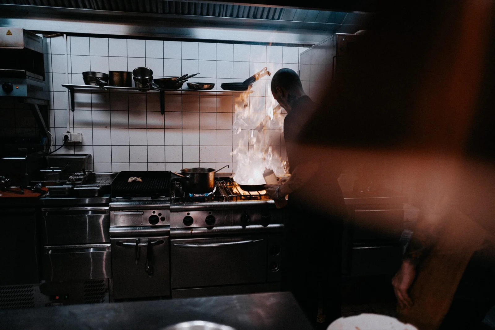 Cuisinier devant une flambée dans une cuisine professionnelle